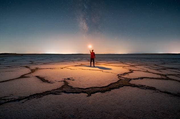 Creative Highlight Symbolbilder MR_ID31250_22563_MiguelGarcia.jpg, MR_ID31250_22562_JavierMartinez.jpg Back view of an unrecognizable man holding a light source, standing on vast salt flats under a starry milky way sky. The landscape features unique patterns, creating an enchanting scene. Model Released JavierMartinez_ID31250_1060630_002 Copyright: xJavierxMartinezx RECORD DATE NOT STATED