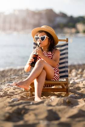 MR_ID31274_22583_MayaBosquetCarli.jpg, MR_ID31274_22584_LeoBosquetCarli.jpg A cute little girl in swimwear and heart shaped sunglasses, relaxing on a striped beach chair while sipping a drink through a straw. She s enjoying the summer sun and sandy beach scene. Model Released MagdalenaCarli_ID31274_1062185_001 Copyright: xMagdalenaxCarlix