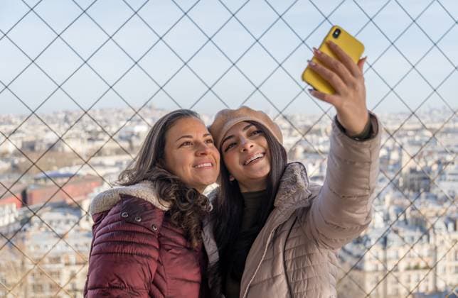 IMAGO Creative, Winter, In der Stadt MR_ID31189_22495_MariaIsabelBenjumeaDuque.jpg, MR_ID31189_22496_NataliaDuqueJaramillo.jpg Two women happily take a selfie in front of the Eiffel Tower on a chilly morning. The bright sky and winter coats highlight their joyous tourist experience in Paris, France. Model Released NicoescobarPhoto_ID31189_1058171_020 Copyright: xNicoescobarxPhotox