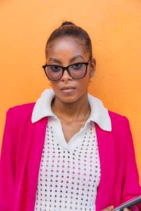 MR_ID31069_22423_WendyMedinaContreras.jpg A confident Black businesswoman in a bright pink blazer stands against a vivid orange wall in Cartagena de Indias, Colombia, embodying professional elegance and vibrant Caribbean culture Model Released VictorCuenca_ID31069_1053912_015 Copyright: xVictorxCuencax