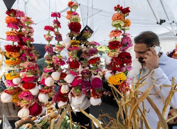 (250929) -- TORONTO, Sept. 29, 2025 -- A man looks at garlic ornaments during the 14th Toronto Garlic Festival in Toronto, Canada, on Sept. 28, 2025. The annual festival was held here on Sunday to celebrate garlic s diverse culinary and cultural uses, with many visitors in attendance. (Photo by Xinhua) CANADA-TORONTO-GARLIC FESTIVAL ZouxZheng 