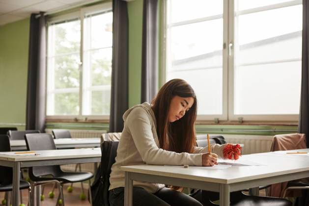 Teenage girl with Autism Spectrum Disorder squeezing stress ball while writing educational exam in school Sweden, Stockholm, model released, property released Copyright: xMaskotx , MA120457 MA120457