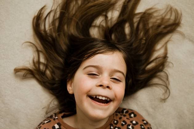 Young Girl with Brown Hair Laughing on Soft Carpet Calgary, Alberta, Canada R_AMST250930-1776667-01 ,model released, Symbolfoto ,property released