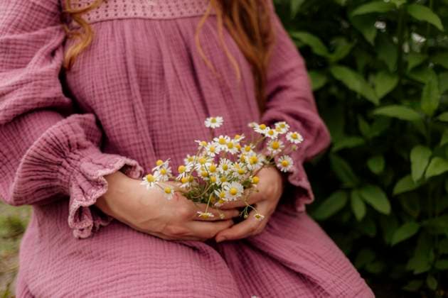 Woman holding chamomile flowers with closed eyes outdoors Amsterdam, North Holland, Netherlands R_RTBZ25093044-1843211-01