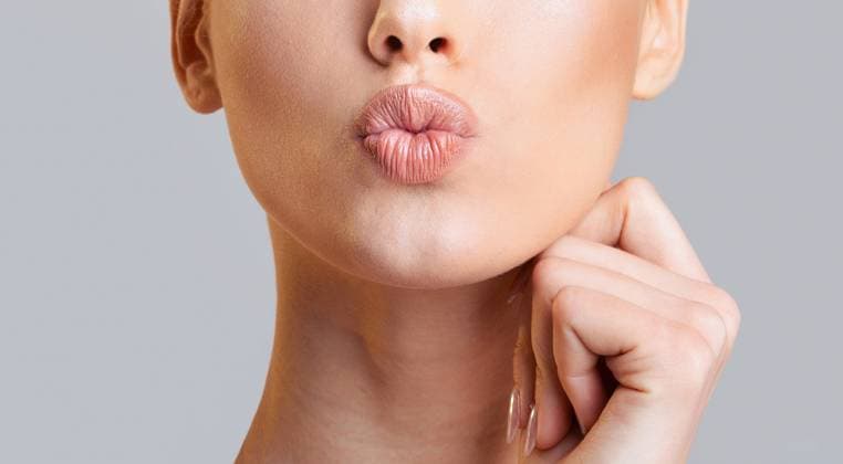 Woman Lips Pouting With a Hand on Her Chin Cropped of woman face, showcasing her lips as they pout in a slightly seductive expression. She has a hand resting on her chin, adding a touch of sensuality to the overall pose, cropped, model released, , 60769262.jpg RECORD DATE NOT STATED
