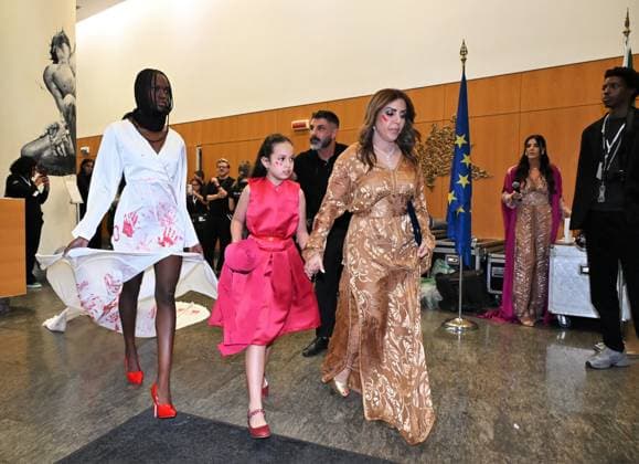 Milan, Italy Il Filo del Coraggio fashion show event dedicated to women against violence by the Italian-Moroccan designer Hnia Harrati at the Fontana e Rocce of Palazzo Lombardia during Fashion Week. Celebrities, institutions and associations are present. In the photo: Hnia Harrati with a model and a child closes the fashion show.  Copyright: xNickxZonnax xipa-agency.netx xNickxZonnax IPA_Agency_IPA66058223