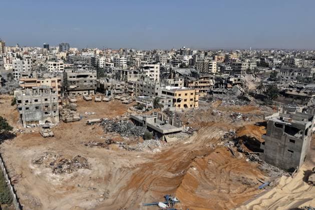 --PHOTO TAKEN DURING A CONTROLLED EMBED TOUR WITH THE ISRAELI ARMY AND SUBSEQUENTLY EDITED UNDER MILITARY SUPERVISION-- This picture taken during a media tour organised by the Israeli armys shows Israeli army tanks and armoured personnel carriers stationed amid war-damaged buildings near the Jordanian Field Hospital in Gaza City, on Friday, October 3, 2025. Israel s military said on October 4 that it was continuing its offensive in Gaza City and warned residents not to return to the area, even after US President Donald Trump urged Israel to halt its assault on the territory. Pool photo by Jack Guez  WAX30351004115 JACKxGUEZ