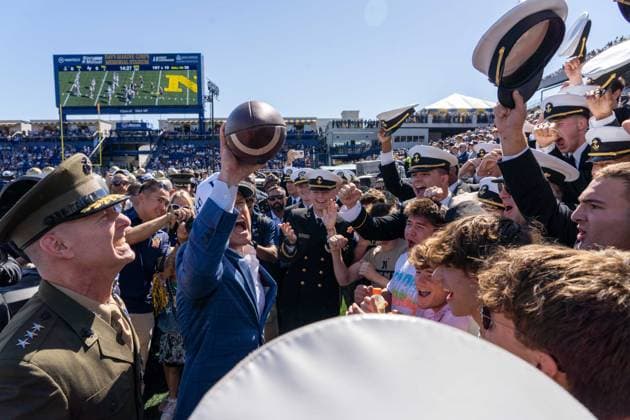 October 4, 2025, Annapolis, Maryland, USA: Secretary of War PETE HEGSETH lifts up a football and yells into a crowd of Midshipmen to hype them up as they cheer back at the Navy vs. Air Force football game. Annapolis USA - ZUMAs365 20251004_znp_s365_008 Copyright: xJoeyxSussmanx