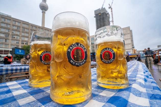 Paulaner Bier, drei Mass Bier, Oktoberfest am Alexanderplatz in Berlin, 4. Oktober 2025 Deutschland, Berlin, 4. Oktober 2025, Paulaner Helles, Münchner Bier, drei Maß Bier stehen auf dem Biertisch, Oktoberfest am Alexanderplatz in Berlin, vom 26. September bis 5. Oktober 2025, Biergarten im Regen, schlechtes Wetter, bedeckter Himmel, Samstagnachmittag, wenig Besucher am Nachmittag, Berliner Fernsehturm im Hintergrund, Wochenende,