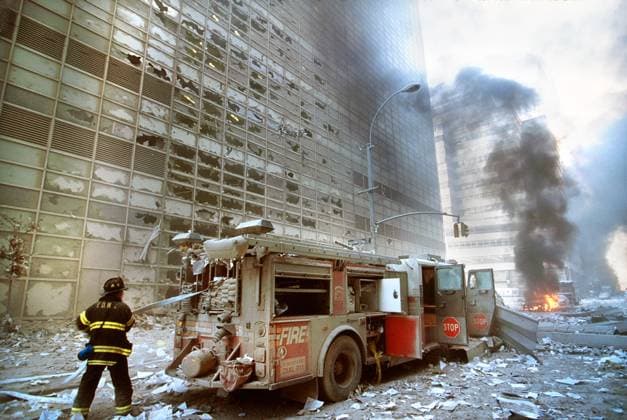 terrorism, World Trade Center, New York City, 9 11, historical, April 26, 2022, New York City, New York, USA: New York City fire fighter pulling water hose from fire truck amid debris and burning buildings following September 11th terrorist attack on World Trade Center, New York City, New York, USA, Unidentified Artist Copyright: xJTxVintagex
