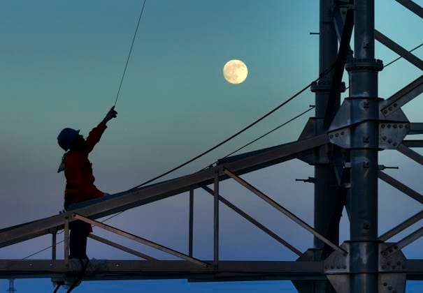 (251006) -- BEIJING, Oct. 6, 2025 -- A drone photo taken on Oct. 6, 2025 shows a worker against the backdrop of a full moon in Hengyang, central China s Hunan Province. Monday marks this year s Mid-Autumn Festival, which is celebrated annually on the 15th day of the eighth month in the Chinese lunar calendar. People across China admire the full moon to celebrate the traditional holiday. (Photo by Xinhua) CHINA-MID-AUTUMN FESTIVAL-MOON (CN) CaoxZhengping 