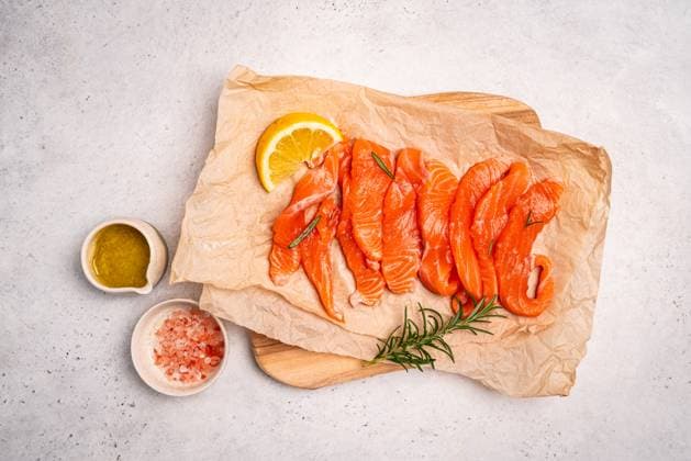 Traditioneller frischer norwegischer Lachs in Scheiben Traditional Norwegian fresh salmon in slices, salted fish or salmon ceviche with lemon and rosemary, top view on white background (License=RF) Copyright: xZoonar.com TatianaxGoskovax 24019424