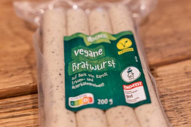 Vegane Bratwurst Produktfoto im Zusammenhang mit EU-Diskussion über Bezeichnungen pflanzlicher Fleischalternativen 12.10.25, Selters: Symbolfoto, Illustrationsbild, Symbolbild, Illustrationsfoto, Alltagsszene Nahaufnahme einer Verpackung Vegane Bratwurst der Marke Vemondo auf einer Holzoberfläche. Das Produkt besteht aus pflanzlichen Zutaten wie Rapsöl, Erbsen- und Ackerbohnenprotein. Symbolbild zur EU-Debatte über die Verwendung traditioneller Fleischbegriffe wie Bratwurst, Schnitzel oder Steak für vegane und vegetarische Lebensmittel. Das Bild thematisiert Nachhaltigkeit, Konsumverhalten und die Entwicklung pflanzlicher Alternativen im europäischen Lebensmittelmarkt. Selters Hessen Deutschland *** Vega Copyright: xThorstenxWagnerx