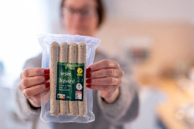 Vegane Bratwurst Symbolfoto zur EU-Debatte um Bezeichnungen pflanzlicher Fleischalternativen 12.10.25, Selters: Symbolfoto, Illustrationsbild, Symbolbild, Illustrationsfoto, Alltagsszene Eine Person hält eine Verpackung Vegane Bratwurst der Marke Vemondo in den Händen. Der Hintergrund ist unscharf, der Fokus liegt auf dem Produkt. Das Bild steht sinnbildlich für die Diskussion über die Verwendung traditioneller Fleischbegriffe wie Bratwurst oder Schnitzel für pflanzliche Produkte in der Europäischen Union. Symbolfoto zu Themen wie Lebensmittelkennzeichnung, Verbraucherinformation, Nachhaltigkeit und der rechtlichen Einordnung veganer Fleischalternativen im Handel. Selters Hessen Deutschland *** Vegan bratwurst Copyright: xThorstenxWagnerx