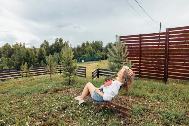 woman outdoors reads book in village. small trees, escape. Moscow, Moscow, Russia R_AIAI251009-1862195-01 ,model released, Symbolfoto ,property released