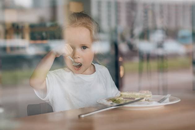 Toddler eating green cake with spoon at cafe, shot through window Saint Petersburg, Saint Petersburg, Russia CR_KSLI251013-1862767-01 ,model released, Symbolfoto