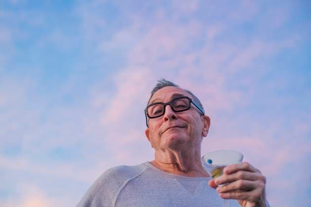 Smiling Senior Man Toasting with Drink at Sunset United States, New Jersey, Asbury Park CR_SUBARR251013-1840846-01 ,model released, Symbolfoto