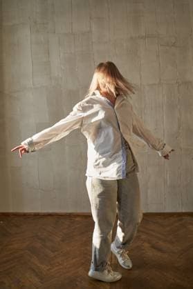 Kaukasischer weiblicher junger Erwachsener tanzt drinnen in warmem Licht und trägt Freizeitkleidung Caucasian female young adult dancing indoors in warm light wearing casual outfit with wooden floor background. (License=RF) ,model released, Symbolfoto Copyright: xZoonar.com ElenaxSafonovax 23924001 ,model released, Symbolfoto ,property released