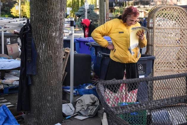 October 16, 2025, Toronto, On, Canada: An encampment resident reads a Fire Marshal s notice of removal as Toronto city workers prepare to clear the unhoused persons encampment at St. Stephen-in-the-Fields Church, in Toronto, on Thursday, Oct. 16, 2025. Toronto Canada  - ZUMAc35_ 20251016_zaf_c35_014 Copyright: xChrisxYoungx