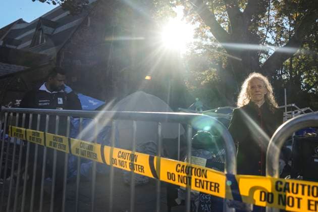 October 16, 2025, Toronto, On, Canada: Rev. Canon Maggie Helwig, right, stands amid structures as Toronto city workers prepare to clear the unhoused persons encampment at St. Stephen-in-the-Fields Church, in Toronto, on Thursday, Oct. 16, 2025. Toronto Canada - ZUMAc35_ 20251016_zaf_c35_017 Copyright: xChrisxYoungx