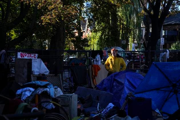October 16, 2025, Toronto, On, Canada: An encampment resident stands among structures as Toronto city workers prepare to clear the unhoused persons encampment at St. Stephen-in-the-Fields Church, in Toronto, on Thursday, Oct. 16, 2025. Toronto Canada  - ZUMAc35_ 20251016_zaf_c35_020 Copyright: xChrisxYoungx