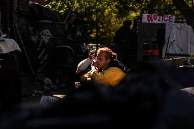 News Bilder des Tages October 16, 2025, Toronto, On, Canada: An encampment resident sits among structures as Toronto city workers prepare to clear the unhoused persons encampment at St. Stephen-in-the-Fields Church, in Toronto, on Thursday, Oct. 16, 2025. Toronto Canada  - ZUMAc35_ 20251016_zaf_c35_035 Copyright: xChrisxYoungx