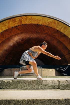 Woman dances in a low lunge on stone steps before wooden stage Boston, Massachusetts, United States CR_FKNH251016-1849065-01 ,model released, Symbolfoto