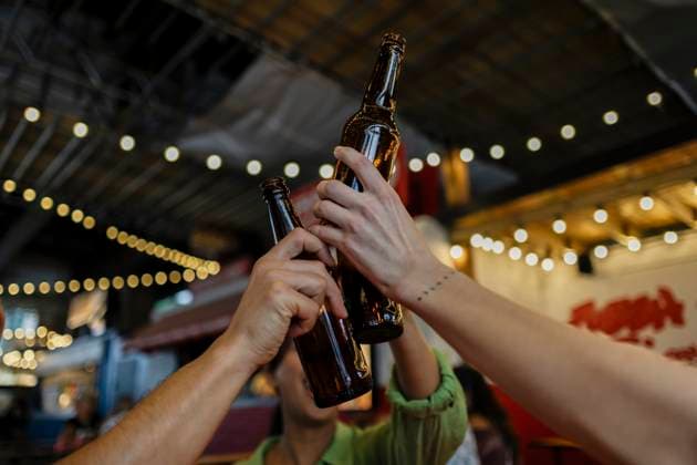 Friends celebrating with beer bottles in a brewery at night model released, Symbolfoto property released, ASGF07052
