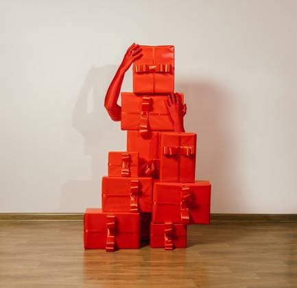 Red gloved hands arranging monochrome red gift boxes in a surreal style model released, Symbolfoto, AAF00261