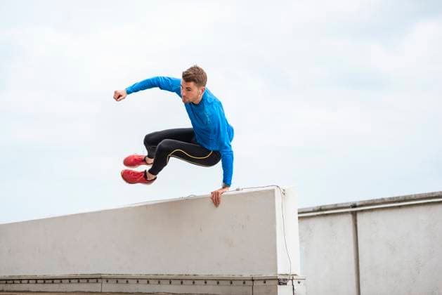 Athlete jumping over urban rooftop practicing parkour outdoors model released, Symbolfoto, DIGF25722