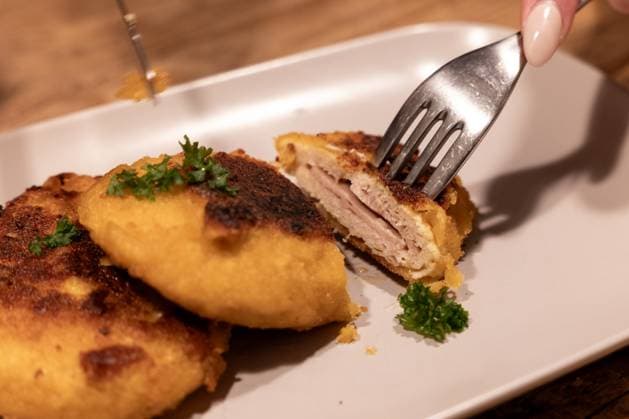 Veganes Cordon Bleu angerichtet Symbol für EU-Streit um Produktbezeichnungen 25.10.25, Selters: Symbolfoto, Illustrationsbild, Symbolbild, Illustrationsfoto, Alltagsszene Eine Person schneidet ein veganes Cordon Bleu auf, das auf einem Teller serviert ist. Das pflanzliche Fleischersatzprodukt zeigt den typischen Schichtenaufbau eines klassischen Cordon Bleu. Das Foto steht im Kontext der EU-Debatte über die Verwendung traditioneller Fleischbezeichnungen für vegane und vegetarische Alternativen. Aufnahme in Deutschland, 2025. Selters Hessen Deutschland *** Vegan cordon bleu served Symbol for EU dispute over product names 25 10 25, Selters Symbol photo, illustration image, symbol image, illustration photo, everyday scene A person cu Copyright: xThorstenxWagnerx