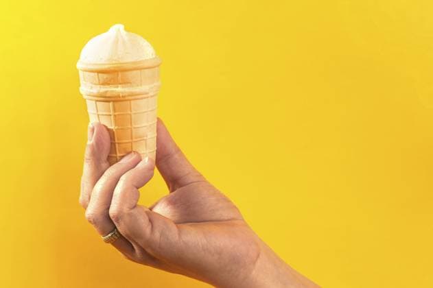 Waffelbecher mit Eiscreme in der Hand auf gelbem Hintergrund Waffle cup with ice cream in hand on yellow background Copyright: imageBROKER UGORENKOVxALEKSANDR ibxiqx14598702.jpg