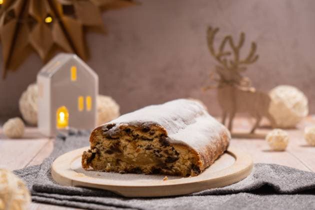 Weihnachtsstollen in Weihnachtsbeleuchtung und Dekoration. Traditionelle süße Früchtebrot mit Puderzucker festliche Gebäck Dessert. Weihnachtsbäckerei Lebensmittel Christmas Stollen in Christmas lights and decoration. Traditional sweet fruit loaf with icing sugar festive pastry dessert. Holiday baking food concept. (License=RF) Copyright: xZoonar.com AnastasiiaxYanishevskax 24103893
