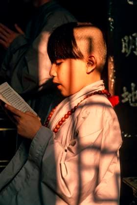 Historisches Farbfoto eines jungen Mönchsnovizen beim Lesen und Singen von buddhistischen Textzeilen im Licht der durch ein Fenster scheinenden Nachmittagssonne, Hue, Vietnam, 25. Nov. 1992 Historisches Farbfoto eines jungen Mönchsnovizen beim Lesen und Singen von buddhistischen Textzeilen im Licht der durch ein Fenster scheinenden Nachmittagssonne, Hue, Vietnam, 25. Nov. 1992 (License=RM) Copyright: xZoonar.com þx 24141403