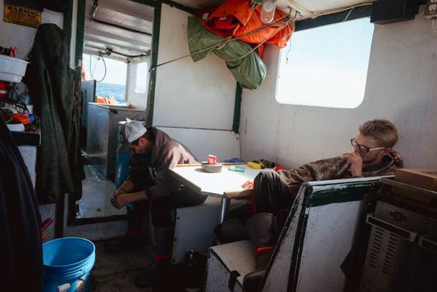 Commercial fishing and bycatch off the coast of Maine, USA - 28 Sept 2022 September 28, 2022, Portland, Maine, United States: Crew members aboard a commercial fishing boat take a break in a cabin on a sunny day off the coast of Maine. A board a gillnet fishing boat, crew haul their catch of monkfish, pollock, and cod from the early hours of the morning until late at night. The fishing industry in Maine has recently taken a blow with a new set of restrictions on fishing and the environmental organization Seafood Watch recommending for people to avoid eating American lobster. This listing and regulation pose fresh threats to fishers livelihoods. While fisherfolk argue that lines pose only a minor risk to the incidental capture of endangered Copyright: xMaileexOsten-Tanx