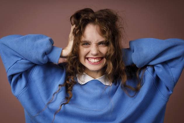 Glückliche überraschte junge erwachsene Frau, die einen winterblauen Pullover trägt und mit ihren Händen den Kopf hält und mit freudigem Lächeln in die Kamera schaut Happy surprised young adult woman wearing winter blue sweater and hold head with her hands looking at camera with joyful smile Copyright: imageBROKER Maxx4e ibxiqx15483804.jpg ,model released, Symbolfoto ,property released