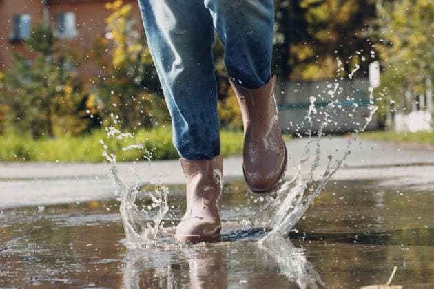 Frau trägt Regengummistiefel, läuft und springt in eine Pfütze mit Wasserspritzer und Tropfen im Herbstregen Woman wearing rain rubber boots walking running and jumping into puddle with water splash and drops in autumn rain Copyright: imageBROKER Maxx4e ibxiqx15481248.jpg ,model released, Symbolfoto ,property released