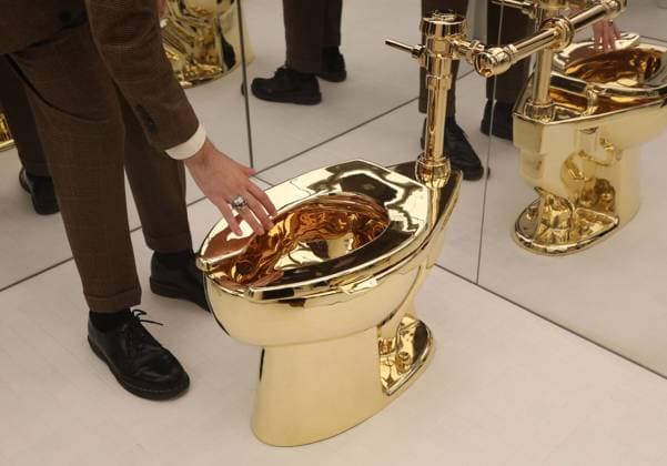 November 7, 2025, New York, New York, USA: A man examines Maurizio CattelanÃ¢â‚¬â ¢s America (2016): a fully functional toilet made from just over 100 kilograms of solid 18-karat gold, estimate starting at $10 million, seen on display during November Marquee Week 2025 during SothebyÃ¢â‚¬â ¢s Opening of the New Global Headquarters at the Breuer. New York USA - ZUMAk03_ 20251107_zaf_k03_011 Copyright: xNancyxKaszermanx
