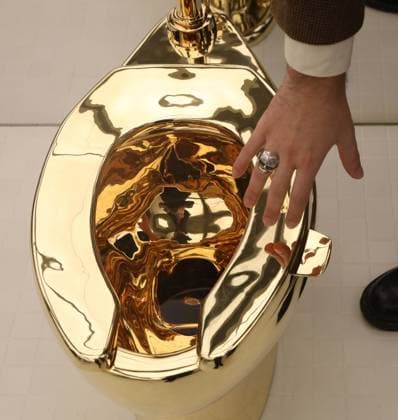 November 7, 2025, New York, New York, USA: A man examines Maurizio Cattelan s America (2016): a fully functional toilet made from just over 100 kilograms of solid 18-karat gold, estimate starting at $10 million, seen on display during November Marquee Week 2025 during Sotheby s Opening of the New Global Headquarters at the Breuer. New York USA - ZUMAk03_ 20251107_zaf_k03_027 Copyright: xNancyxKaszermanx