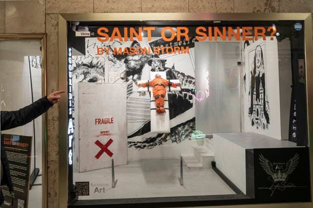 November 8, 2025, Basel, Basel-Stadt, Switzerland: A man points a finger to a sculpture depicting the US President Donald Trump in a prisoner orange jumpsuit and strapped to a cross looking like a death row strapped-down bed, is displayed in a gallery of the city centre of Basel, Switzerland Basel Switzerland - ZUMAp199 20251108_zip_p199_001 Copyright: xMatteoxPlacuccix