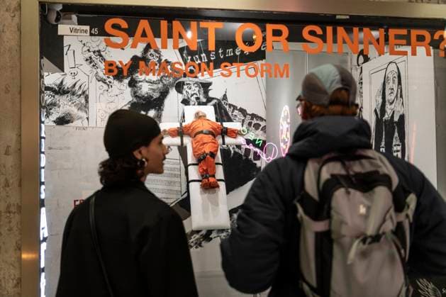 November 8, 2025, Basel, Basel-Stadt, Switzerland: People looking at a sculpture depicting the US President Donald Trump in a prisoner orange jumpsuit and strapped to a cross looking like a death row strapped-down bed, is displayed in a gallery of the city centre of Basel, Switzerland Basel Switzerland - ZUMAp199 20251108_zip_p199_010 Copyright: xMatteoxPlacuccix