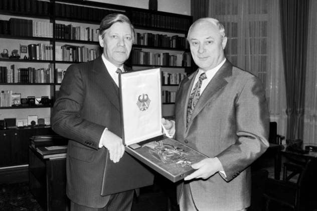 Helmut Schmidt überreicht Georg Leber das Großkreuz des Verdienstordens der Bundesrepublik Deutschland in einem offiziellen Empfangszimmer in Bonn. Beide Männer im Anzug, Leber hält die dekorative Auszeichnung in einer geöffneten Präsentationsschatulle. Bücherregale im Hintergrund deuten auf ein Arbeitszimmer oder eine repräsentative Amtsstube hin. Bonn Nordrhein-Westfalen Deutschland *** Helmut Schmidt presented Georg Liver the Grand Cross of Order of Merit the Federal Republic Germany in a official Reception room in Bonn both Men at Suit, Liver holds the Decorative Award in a open Presentation box Bookcases at Background interpret at a Study Or a Representative Office to Bonn North Rhine Westphalia Germany Copyright: xUnitedxArchivesx xSvenxSimonxArchives SVS_94010000405