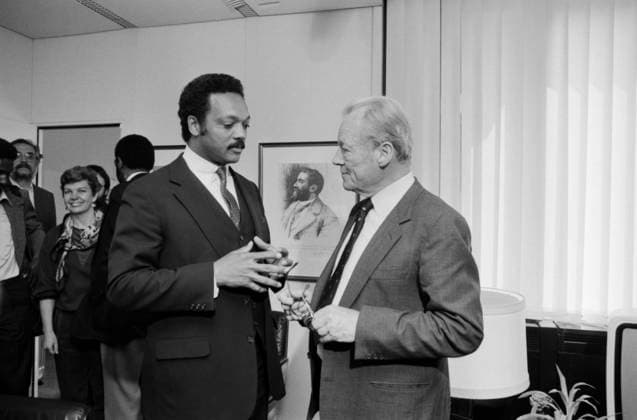 the US American Civil rights activist Jesse Jackson and the SPD Honorary Chairwoman Willy Brandt at Interview on 9 May 1985 in Bonn the Recording shows both Politicians in stimulated Exchange in a Office space, surrounded from Accompanying persons and Press at Background a Portrait from Friedrich Engels Bonn North Rhine Westphalia Germany Copyright: xUnitedxArchivesx xSvenxSimonxArchives SVS_94010001489