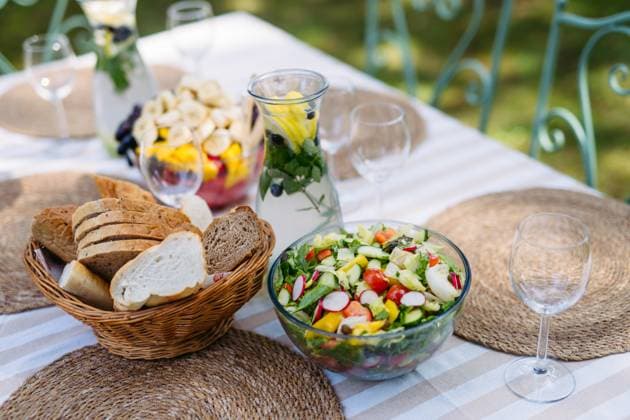 IMAGO Creative, Ostern, Bräuche, Osterbrunch Fresh fruit salad and bread served on outdoor table. Fresh fruit salad and bread served on outdoor table. Garden party food. model released
