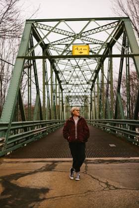 Blond woman smiles outside by bridge in winter sweater Québec City, Quebec, Canada R_WVNP251106-1842439-01 ,model released, Symbolfoto