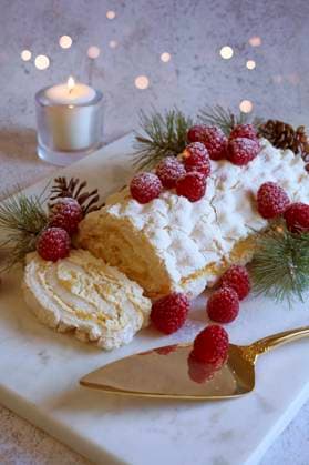 Christmas Buche de Noel White Yule Log Cake with Bokeh Lights on White Marble Board. Christmas Buche de Noel White Yule Log Cake with Bokeh Lights on White Marble Board. Copyright: xMilleflorexImagesx MIL091025-3