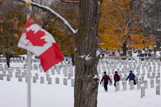 November 11, 2025, Ottawa, On, Canada: People walk among the graves as they make their way to a Remembrance Day ceremony at the national military Cemetery at Beachwood in Ottawa on Tuesday, Nov. 11, 2025. Ottawa Canada  - ZUMAc35_ 20251111_zaf_c35_007 Copyright: xJustinxTangx