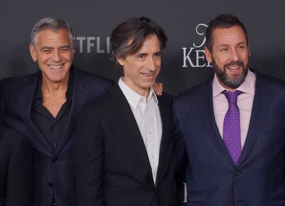 Director Noah Baumbach (C) and cast members George Clooney (L) and Adam Sandler attend the premiere of Netflix s dramatic comedy Jay Kelly at the Egyptian Theatre in the Hollywood section of Los Angeles on Tuesday, November 11, 2025. Storyline: Famous movie actor Jay Kelly embarks on a journey of self-discovery, confronting his past and present with his devoted manager Ron. Poignant and humor-filled, pitched at the intersection of regrets and glories.  LAP2025111115 JIMxRUYMEN