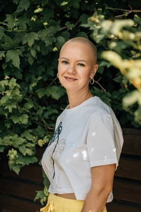Bald woman smiling in white crop tee by green leaves, natural portrait Saint Petersburg, Saint Petersburg, Russia CR_KSLI251110-1866499-01 ,model released, Symbolfoto