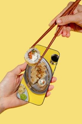 Sushi roll reflected in a phone on a bright background CR_KUAL251110B-1840102-01